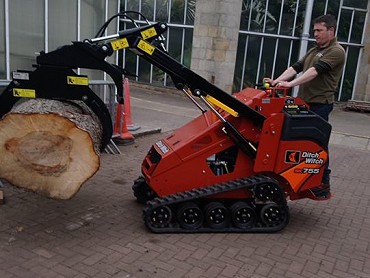 SK755 MINI SKID STEER WITH A LOG GRAB ATTACHMENT